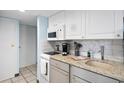 Small condo kitchen with granite countertops and white cabinets at 7000 N Ocean Blvd. # 326, Myrtle Beach, SC 29572