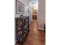 Hallway featuring hardwood flooring, a bookshelf, and access to a bathroom, creating a warm and inviting atmosphere at 801 Benchmade Rd., Conway, SC 29527