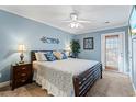 Blue bedroom with king bed, ceiling fan, and private balcony at 118 Seabreeze Dr., Murrells Inlet, SC 29576