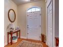 Welcoming entryway with a decorative rug, console table with mirror, and a bright white front door at 1501 Brighton Ln., Longs, SC 29568