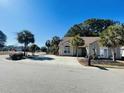 Inviting single-story home with a well-manicured lawn, mature trees, and a spacious driveway under a clear sky at 1501 Brighton Ln., Longs, SC 29568