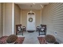 Charming front porch adorned with benches, decorative pillows, and potted plants, creating a cozy entry at 1501 Brighton Ln., Longs, SC 29568