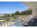 A beautiful ocean view from the balcony with chairs, a table, a white railing, and the lush tropical landscape at 2106 N Ocean Bl N Ocean Blvd. # 211, Myrtle Beach, SC 29577