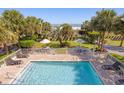 Inviting outdoor pool with a view of the ocean, surrounded by palm trees, lounge chairs, and well-manicured lawns at 2106 N Ocean Bl N Ocean Blvd. # 211, Myrtle Beach, SC 29577