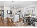 Modern white kitchen with island, stainless steel appliances, and breakfast nook at 244 Gloucester Way, Little River, SC 29566