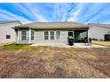 Backyard view of a single-story home featuring a covered patio area, well manicured lawn, and open outdoor space at 344 Tall Palms Way, Little River, SC 29566