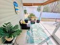 Relaxing screened-in porch with comfortable seating, tropical decor, and views of the backyard at 344 Tall Palms Way, Little River, SC 29566