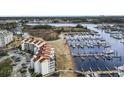 A scenic aerial view showcases the condo complex, marina, and surrounding marshland with access to the waterway at 4390 Bimini Ct. # 206-C, Little River, SC 29566