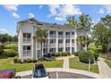 Two-story building with multiple units, balconies, and landscaping; view of golf course at 565 White River Dr. # 10-E, Myrtle Beach, SC 29579