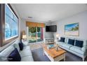 Virtually staged living room with two sofas and access to balcony at 7700 Porcher Dr. # 4202, Myrtle Beach, SC 29572