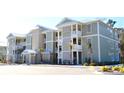 Multi-unit building, light green siding, white trim, balconies, and palm trees at 81 Delray Dr. # 2-C, Murrells Inlet, SC 29576