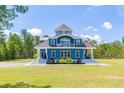 Beautiful blue home featuring a striking exterior with multiple levels, complemented by lush green lawns at 899 Kinlaw Ln., Conway, SC 29527
