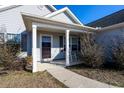 Front porch with rocking chair, white columns, and shrubs at 132 Blue Jacket Dr., Galivants Ferry, SC 29544