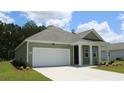 Green one-story house with a white garage door and front porch at 183 Calm Dr., Little River, SC 29566