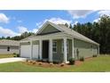 Green one-story house with a white garage door and front porch at 183 Calm Dr., Little River, SC 29566