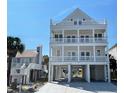 Stunning three-story beach home, showcasing an abundance of outdoor living space and elevated construction at 229 South Waccamaw Dr., Garden City Beach, SC 29576
