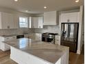 Modern kitchen featuring white cabinets, stainless steel appliances, and a large island with marble countertops at 229 South Waccamaw Dr., Garden City Beach, SC 29576