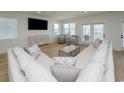 Bright living room with hardwood floors, comfortable seating, and a large TV at 229 South Waccamaw Dr., Garden City Beach, SC 29576