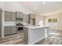 Modern kitchen with stainless steel appliances, a center island, and grey cabinets at 407 Lifestyle Court, Surfside Beach, SC 29575