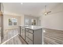 Open-concept kitchen island with grey cabinets overlooks dining area and living area at 407 Lifestyle Court, Surfside Beach, SC 29575
