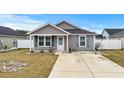 Gray house with white shutters, small front yard, and a concrete driveway at 408 Pigeon Bay St., Longs, SC 29568