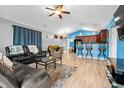 Open living room with vaulted ceiling, hardwood floors, and a view of the kitchen at 408 Pigeon Bay St., Longs, SC 29568
