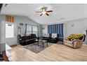 Living room with vaulted ceiling, hardwood floors, and leather furniture at 408 Pigeon Bay St., Longs, SC 29568
