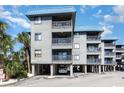 Beachfront property with gray building, balconies, and parking at 6000 N Ocean Blvd. # 205, North Myrtle Beach, SC 29582