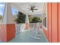 Relaxing front porch with rocking chairs and ceiling fan at 6425 Sw Craller Way, Ocean Isle Beach, NC 28469