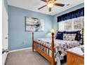 Cozy bedroom featuring a wooden bed frame, a ceiling fan, and a large window at 834 Arezzo Way # 834, Myrtle Beach, SC 29579