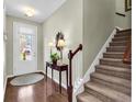 Bright and spacious entryway with hardwood floors, a console table, and stairs leading upstairs at 834 Arezzo Way # 834, Myrtle Beach, SC 29579