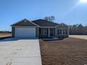 Newly built house with a white garage door and landscaping at Tbd 12 Casey Dr., Green Sea, SC 29545