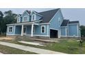 Side view of a blue two-story house with an attached garage and an inviting front porch at 1004 James Island Ave., North Myrtle Beach, SC 29582