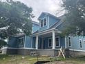 Side view of a blue home featuring a front porch with large pillars and second-story dormer windows at 1004 James Island Ave., North Myrtle Beach, SC 29582