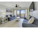 Living room with comfy sofas, TV, and access to balcony at 123 Dogwood Dr. N # 106A, Garden City Beach, SC 29576