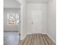 Bright entryway featuring a front door, wood-look flooring and view into a room with a window at 1336 Winding Creek Way, Myrtle Beach, SC 29588