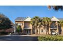 Two story brick building with palm trees and golf cart at 210 Double Eagle Dr. # H-1, Surfside Beach, SC 29575