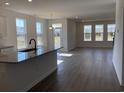 Open-concept living area with wood flooring, bright windows, and a kitchen island at 243 Letha Dr, Longs, SC 29568