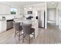 Modern kitchen with white cabinets, granite countertops, and stainless steel appliances at 2604 Watershed Way, North Myrtle Beach, SC 29568