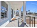 Long front porch with gray floor, black railing, ceiling fan, and view of the street at 434 Stanley Dr., Murrells Inlet, SC 29576