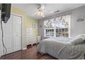 Cozy bedroom with wood flooring, a ceiling fan, and a large window providing natural light at 461 Spauldingwood Rd., Little River, SC 29566