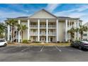 Exterior view of a three-story condo building with palm trees at 5090 Windsor Green Way # 104, Myrtle Beach, SC 29579
