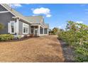 The house and lot feature mature landscaping with a variety of trees and shrubs at 5960 Bolsena Place, Myrtle Beach, SC 29577