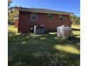 Red brick exterior with lawn, an AC unit, and a water container visible at 7195 Hwy 9, Nichols, SC 29581