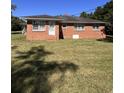 Exterior view of a red brick home with a well maintained grassy backyard at 7195 Hwy 9, Nichols, SC 29581
