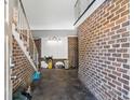 Unfinished garage with exposed brick walls and a staircase at 9095 Highway 701 South, Conway, SC 29527