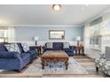 A bright and airy living room with blue sofas, wood floors, and natural light at 100 Bendick Ct., Little River, SC 29566