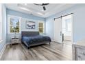 Spacious bedroom with light blue walls, wood-look floors, and a barn door at 1056 Moorhen Ct., Conway, SC 29526