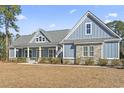 A charming two-story house with gray siding and stone accents at 1056 Moorhen Ct., Conway, SC 29526
