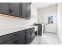 Modern laundry room with dark cabinetry, quartz countertops, and a utility sink at 1056 Moorhen Ct., Conway, SC 29526